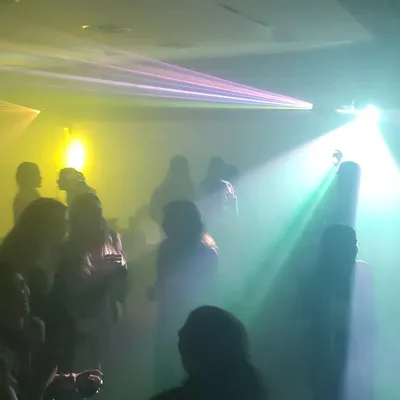 Pista de baile con láseres, humo y luces de colores en un evento