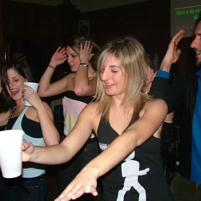 Grupo de invitados bailando y cantando en un evento con karaoke