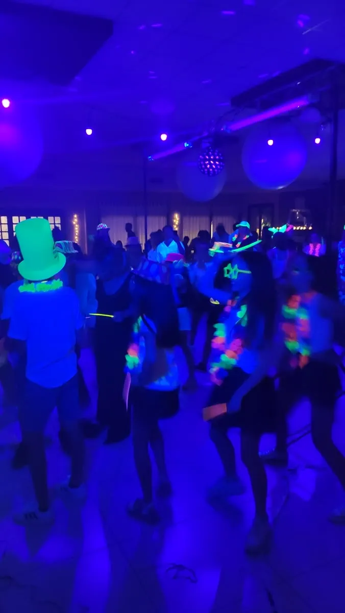 Fiesta con luz negra y accesorios fluorescentes en un show de karaoke